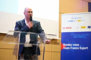 Intervenant masculin prenant la parole sur scène lors de la conférence