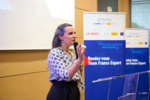 Intervenante féminine prenant la parole sur scène lors des Rendez-vous Team France Export, expert en développement international.