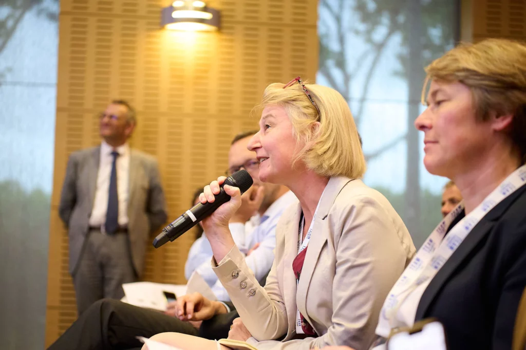 membre du jury posant une question avec microphone lors de la session des Trophées MOCI et Team France Export.